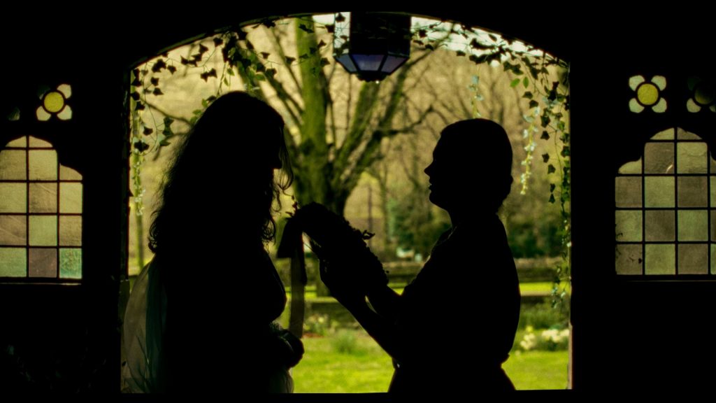 A still from the film Co-eden Meinrm. A silhouette of two women standing in a church door.