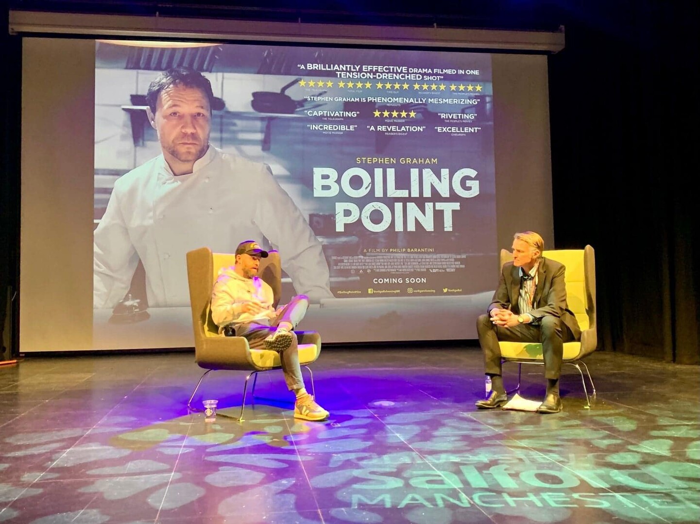 Two men on stage discussing the film Boiling Point.